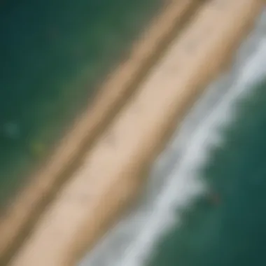 An aerial view of kiteboarders riding along the coastline