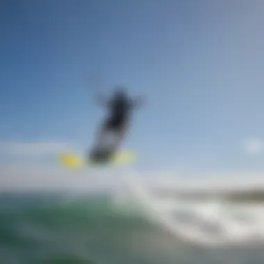 Kiteboarder riding the waves under a clear blue sky