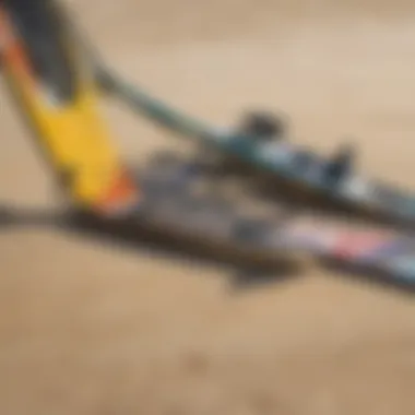 A close-up of kiteboarding equipment set up on the sandy beach.