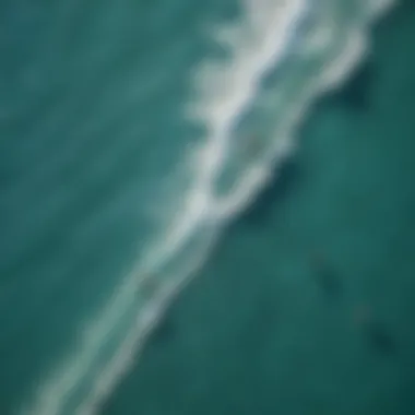 Aerial view of kitesurfers riding waves in clear blue water