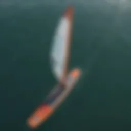 An aerial view of a serene lake with a person gliding on a SUP foil board, harnessing the wind with a wing.